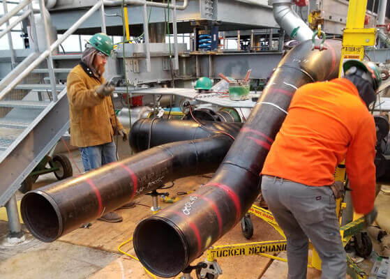 Tucker Mechanical workers installing new piping for a chilled water riser
